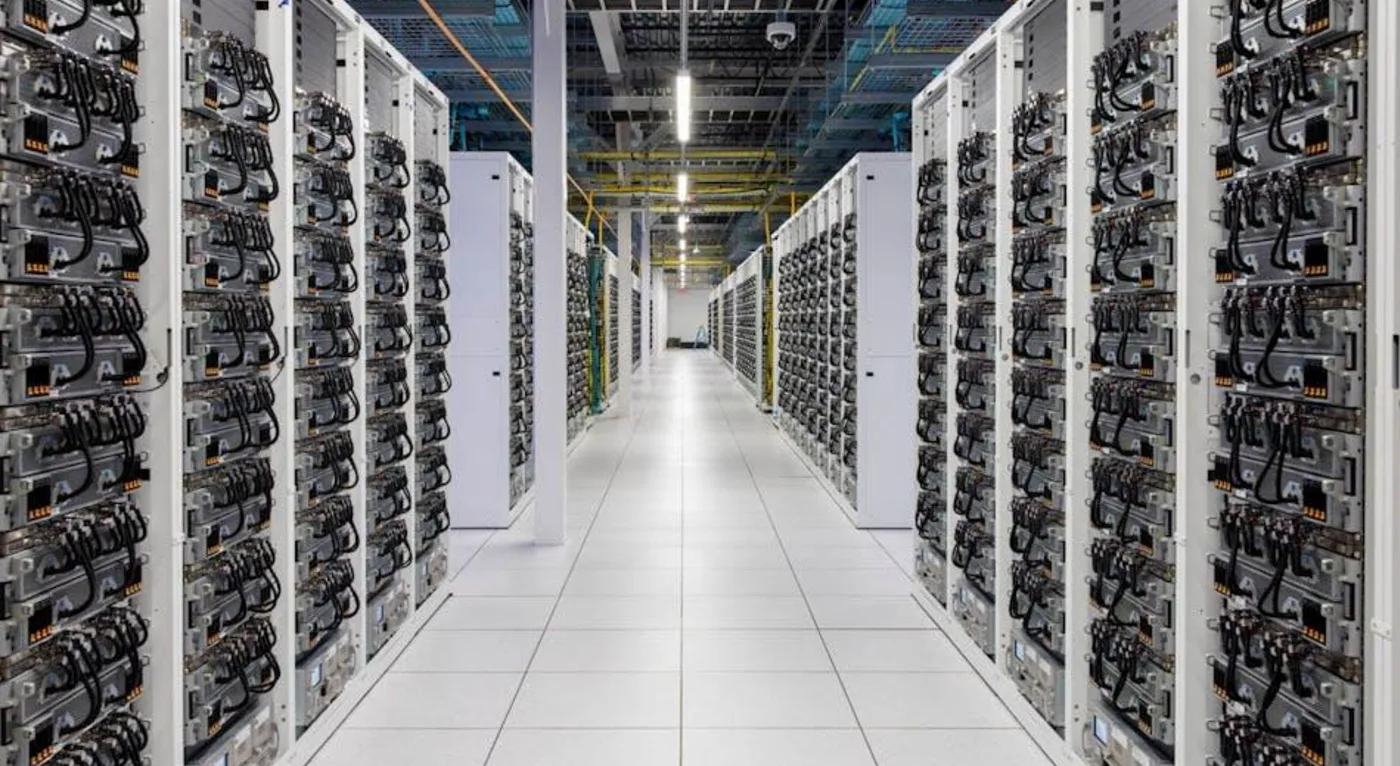 Figuur 7.2 Interieur van het xAI datacenter Colossus in Memphis, Tennessee. Colossus bevat ongeveer 100.000 Nvidia Graphical Processing Units (GPU’s) om taalmodellen te trainen. Uitbreiding naar 200.000 GPU’s zit al in de planning (afbeeldingsbron: https://www.datacenterfrontier.com/machine-learning/article/55244139/the-colossus-ai-supercomputer-elon-musks-drive-toward-data-center-ai-technology-domination).